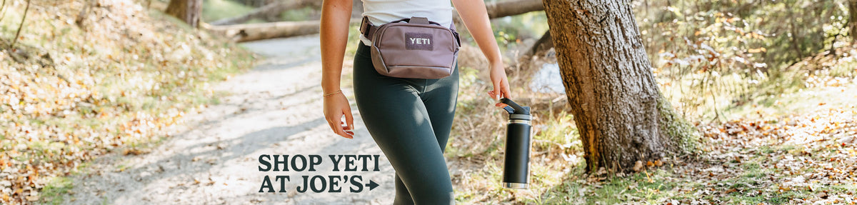Shop all Yeti products at Joes.  Picture shows a woman wearing a yeti waist pack and holding a yeti water bottle.
