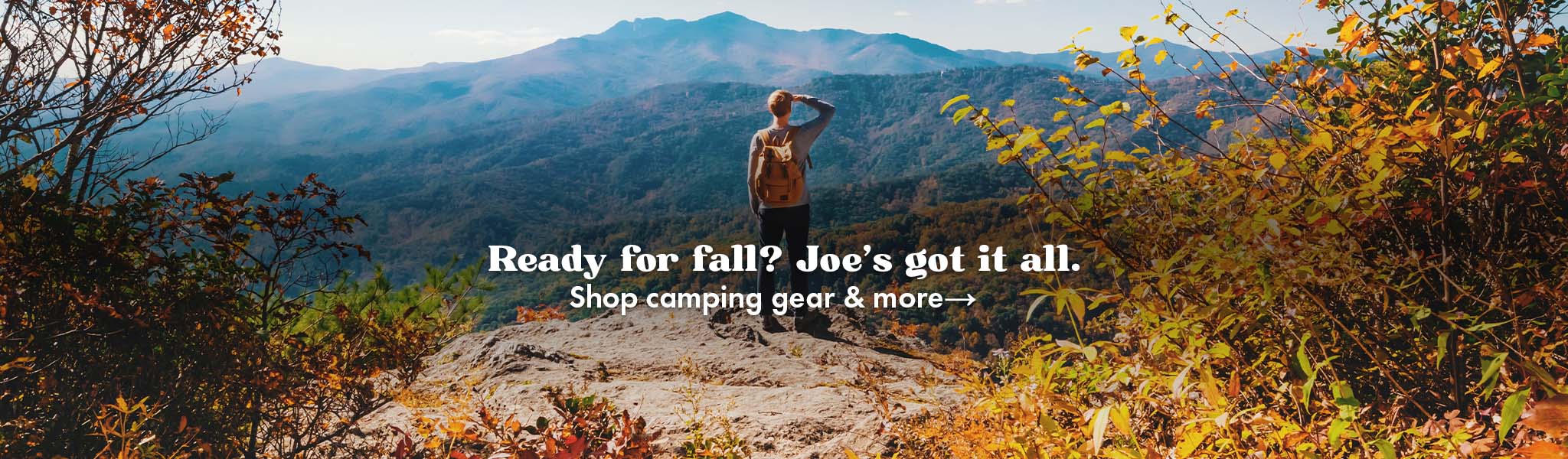 Man standing on a cliff looking over fall trees. Text says: "Ready for fall? Joe's got it all. Shop camping gear and more"