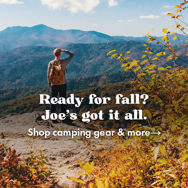 Man standing on a cliff looking over fall trees. Text says: "Ready for fall? Joe's got it all. Shop camping gear and more"