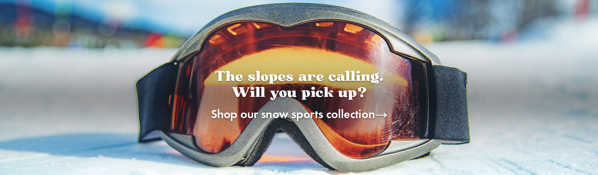 Snow goggles on snowy ground, with text promoting our snow sports collection.