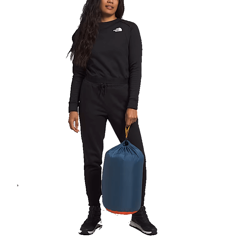 WOMAN HOLDING NORTHFACE WAWONA BED SLEEPING BAG - SHADY BLUE 