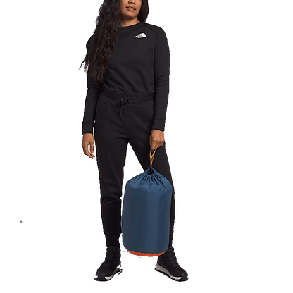 WOMAN HOLDING NORTHFACE WAWONA BED SLEEPING BAG - SHADY BLUE 